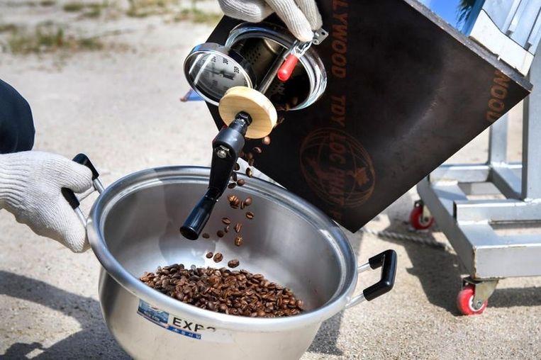 Kate Sweeney from Michael Thomas Coffee pours solar-roasted coffee beans into a steel pot